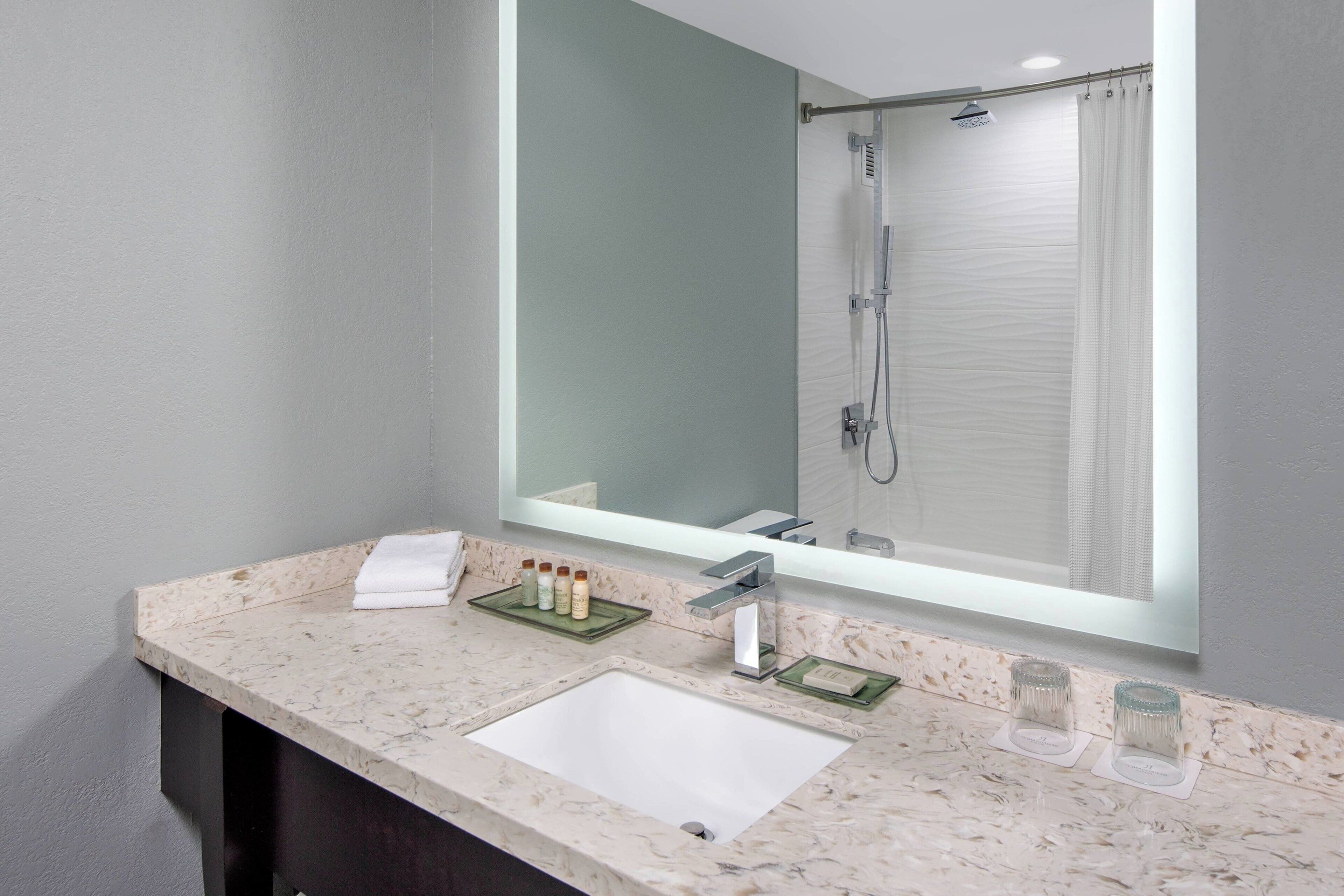 combined shower/bathtub, designer toiletries, hair dryer, towels