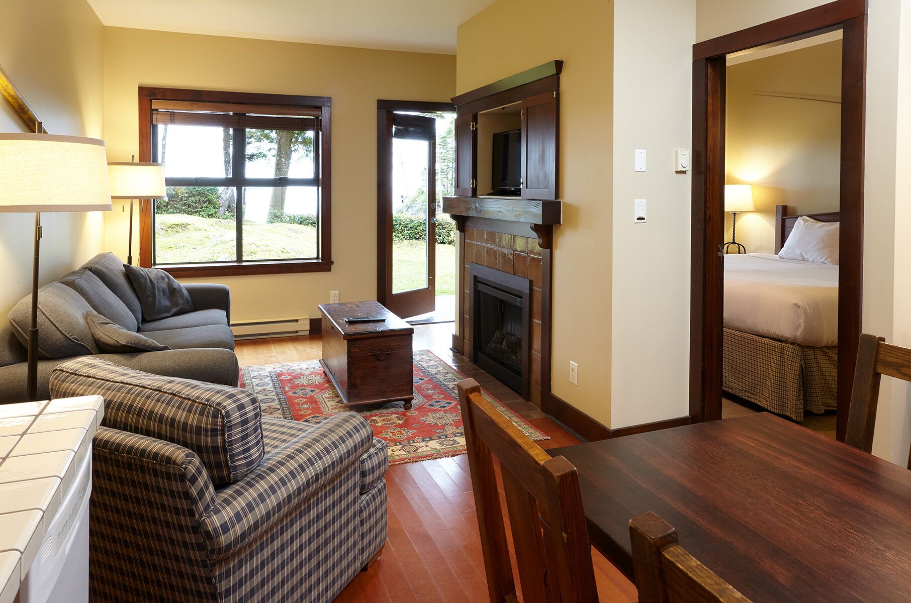 A living room with a fireplace, a sofa, a dining table, and a television.