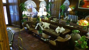 Eine gemütliche Lounge mit Ledersofas, einem Couchtisch und Blumentöpfen.