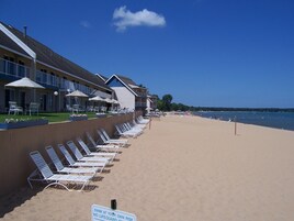 Praia particular, espreguiçadeiras, prática de vôlei de praia 