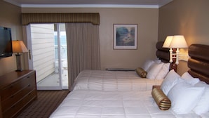 A hotel room with a large bed, two bedside lamps, a dresser, and a painting on the wall. - Pinestead Reef Resort (Traverse City)