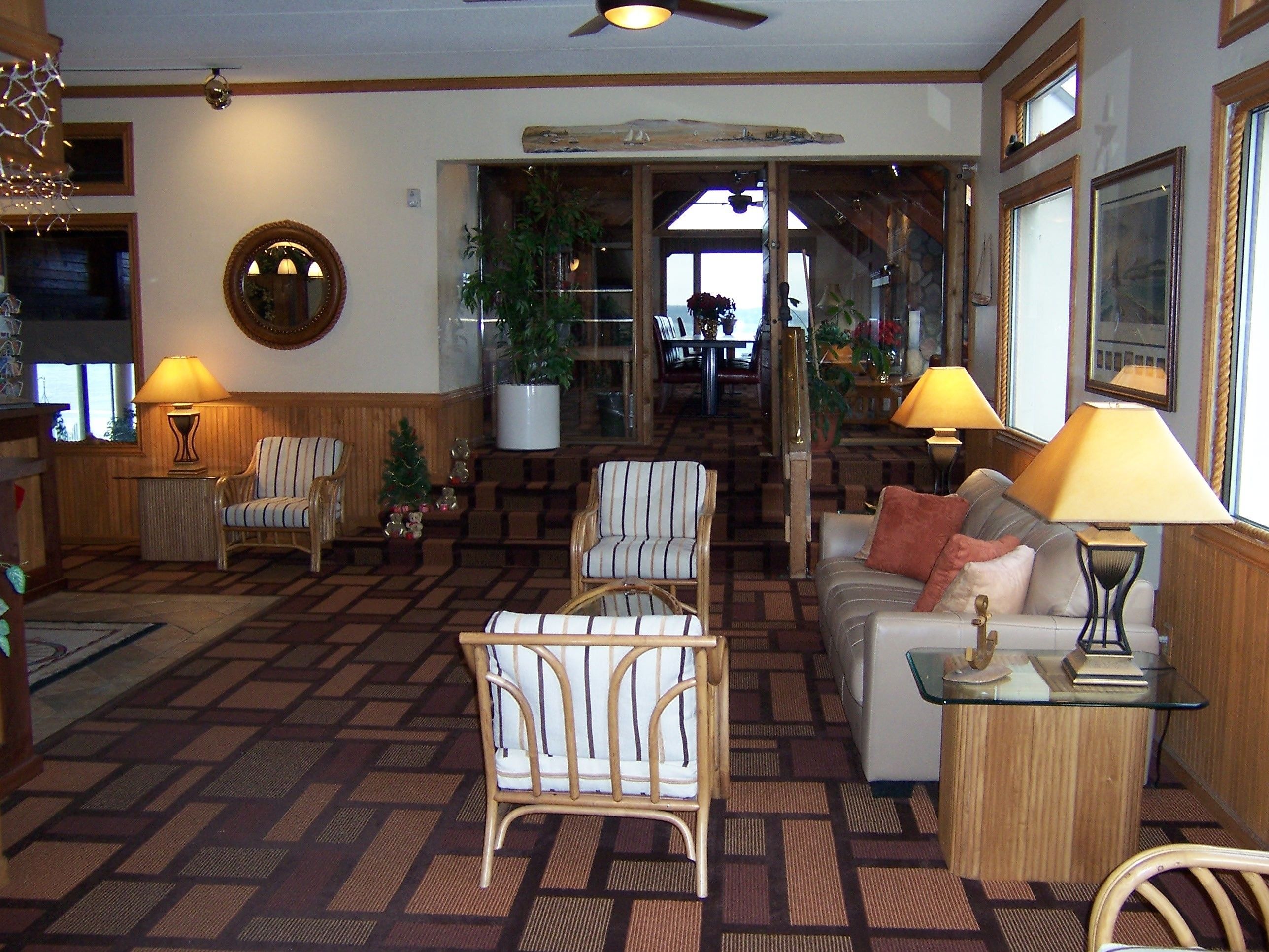 A cozy lobby with striped chairs, a sofa, and a glass coffee table.