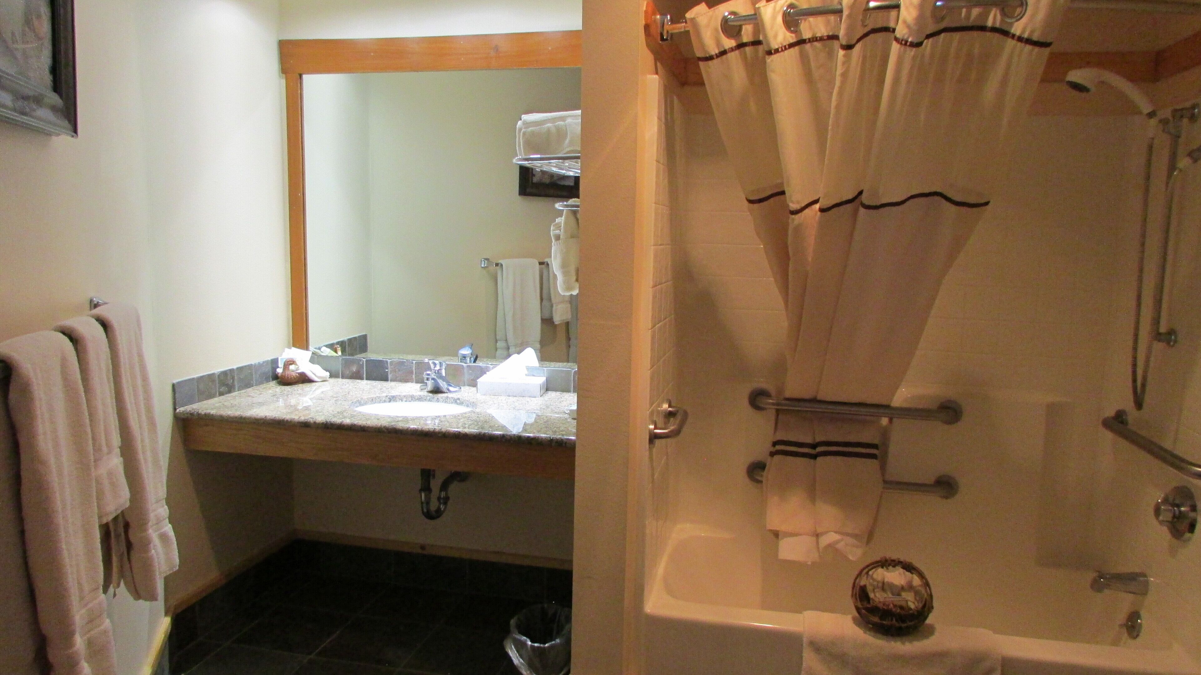 Une salle de bain avec un lavabo, un miroir et une douche.