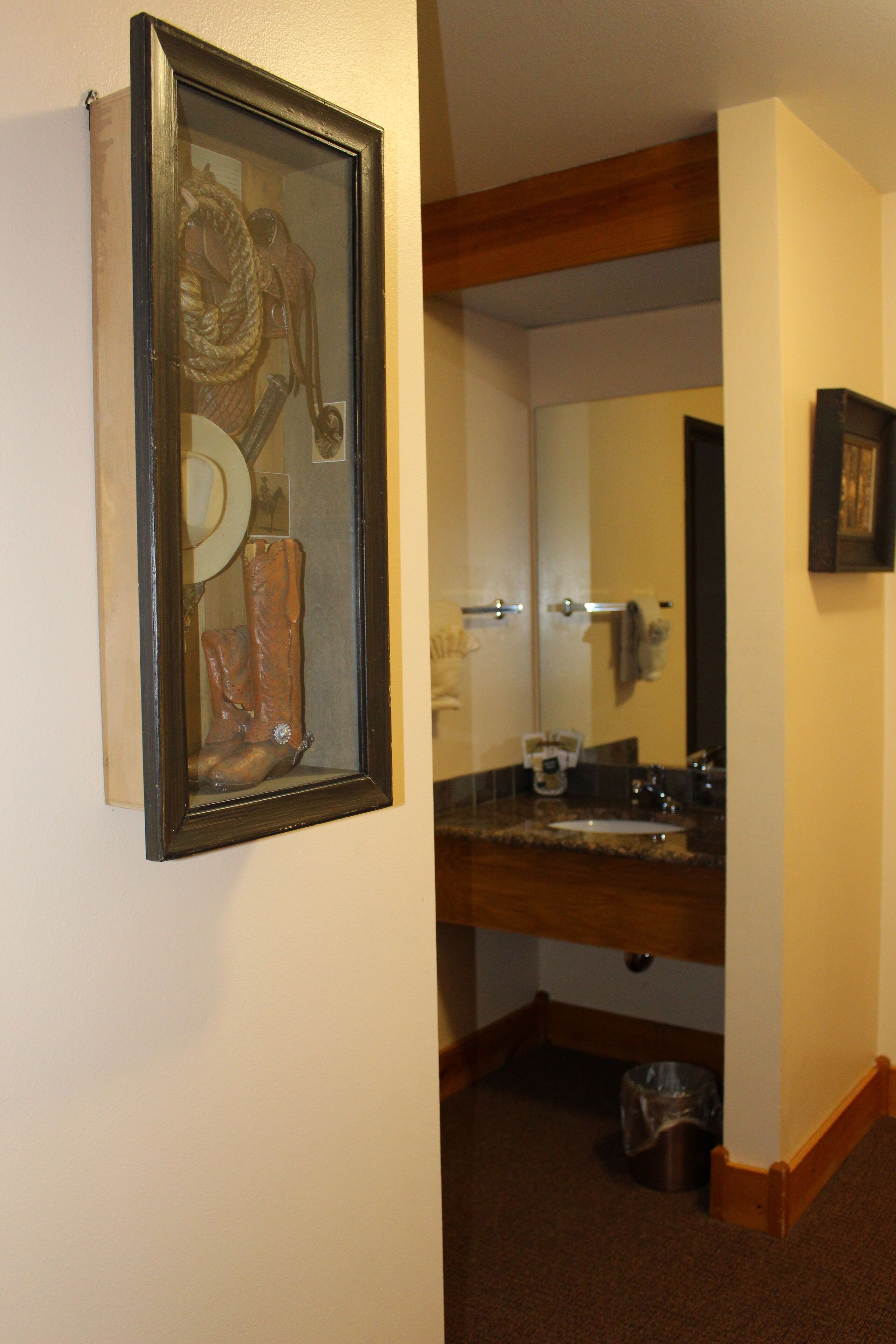 A bathroom with a wooden vanity, a sink, and a mirror.