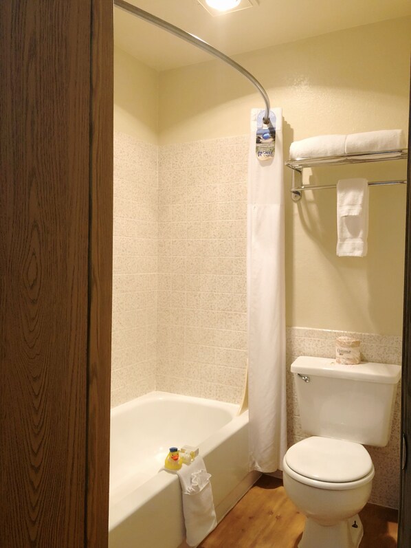 Un baño con bañera, inodoro y cortina de ducha.