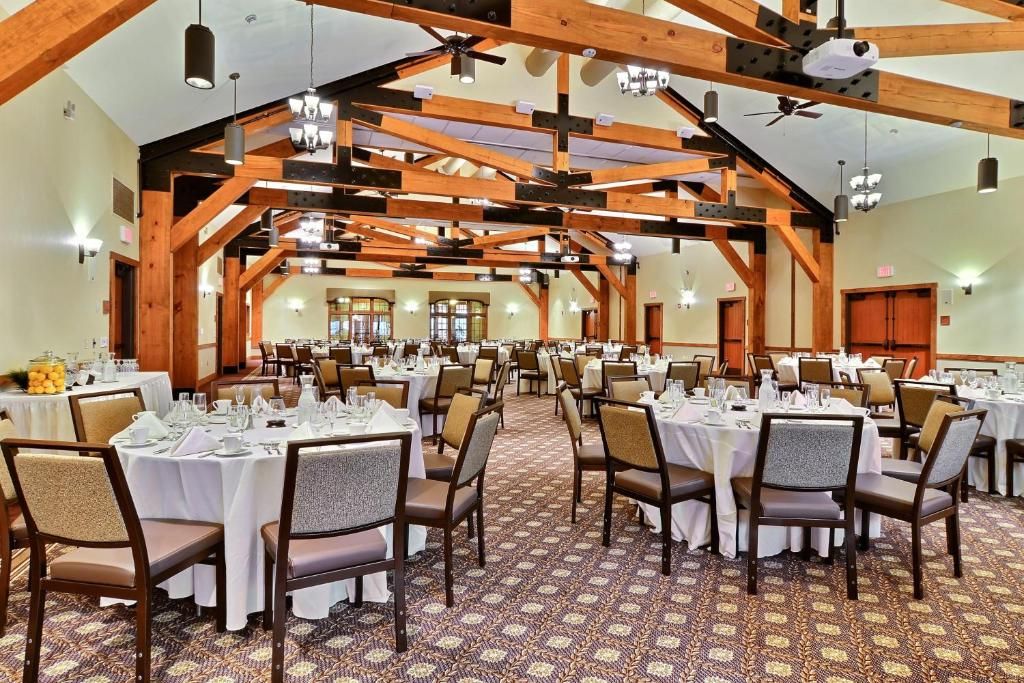 Une salle de banquet avec des tables rondes, des chaises et des ventilateurs de plafond.