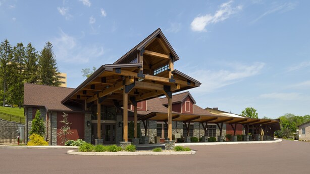 A lodge with a large wooden structure, stone walls, and a clear sky.