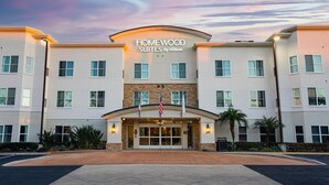 A hotel with a modern design, featuring a central entrance with a flag, and multiple windows on each floor.