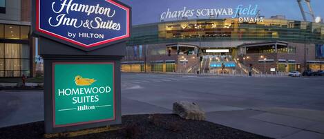 Entrada de hotel con letreros de Hampton Inn & Suites y Homewood Suites by Hilton.