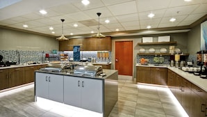 Eine moderne Küche mit Kochinsel, Holzschränken und einer gefliesten Spritzschutzwand.