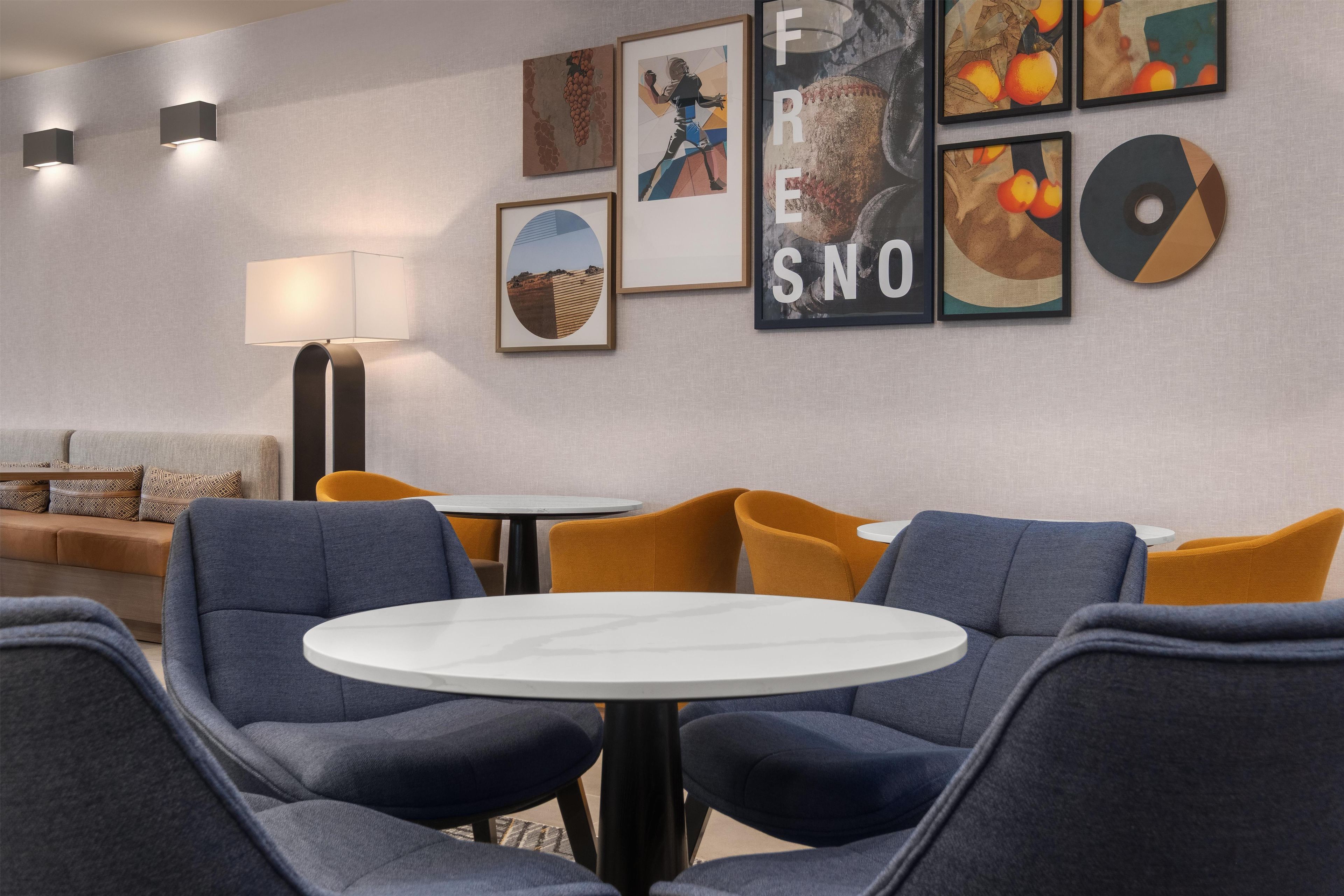 Et moderne loungeområde med siddepladser, et bord og kunst på væggene.