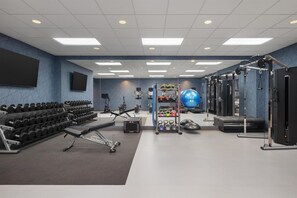 A gym with weightlifting equipment, exercise balls, and dumbbells. - Homewood Suites by Hilton Fresno (Fresno)