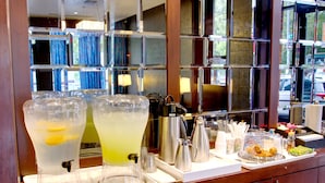 A bar area with two large dispensers of beverages, a coffee pot, and a tray with snacks and condiments. - The Ridge Hotel (New York)
