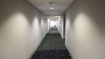 A long, narrow hallway with a patterned carpet and white walls.