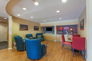 Relax in this spacious living area with comfortable seating, a flat-screen TV, and a kitchen area.