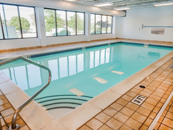 An indoor swimming pool with clear water, a tiled deck, and a windowed wall. - Wingate by Wyndham Erie (Erie)