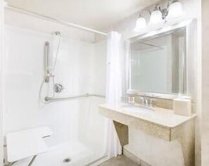 A bathroom with a shower, a sink, and a mirror.