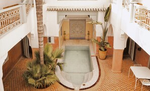 A pool area with a tiled floor, a palm tree, and a potted plant. - Marrakech Riads, Angsana Heritage Collection (Marrakech)