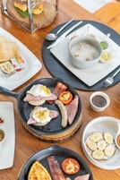 Una mesa de desayuno con varios platos, incluyendo huevos, tocino y tostadas.