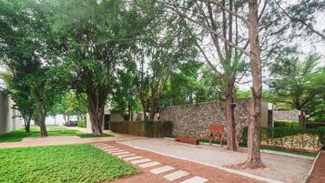 Un jardín ajardinado con muro de piedra, un sendero y un banco.