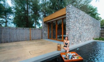 Una casa moderna con fachada de piedra y ventanas amplias, piscina y terraza de madera.