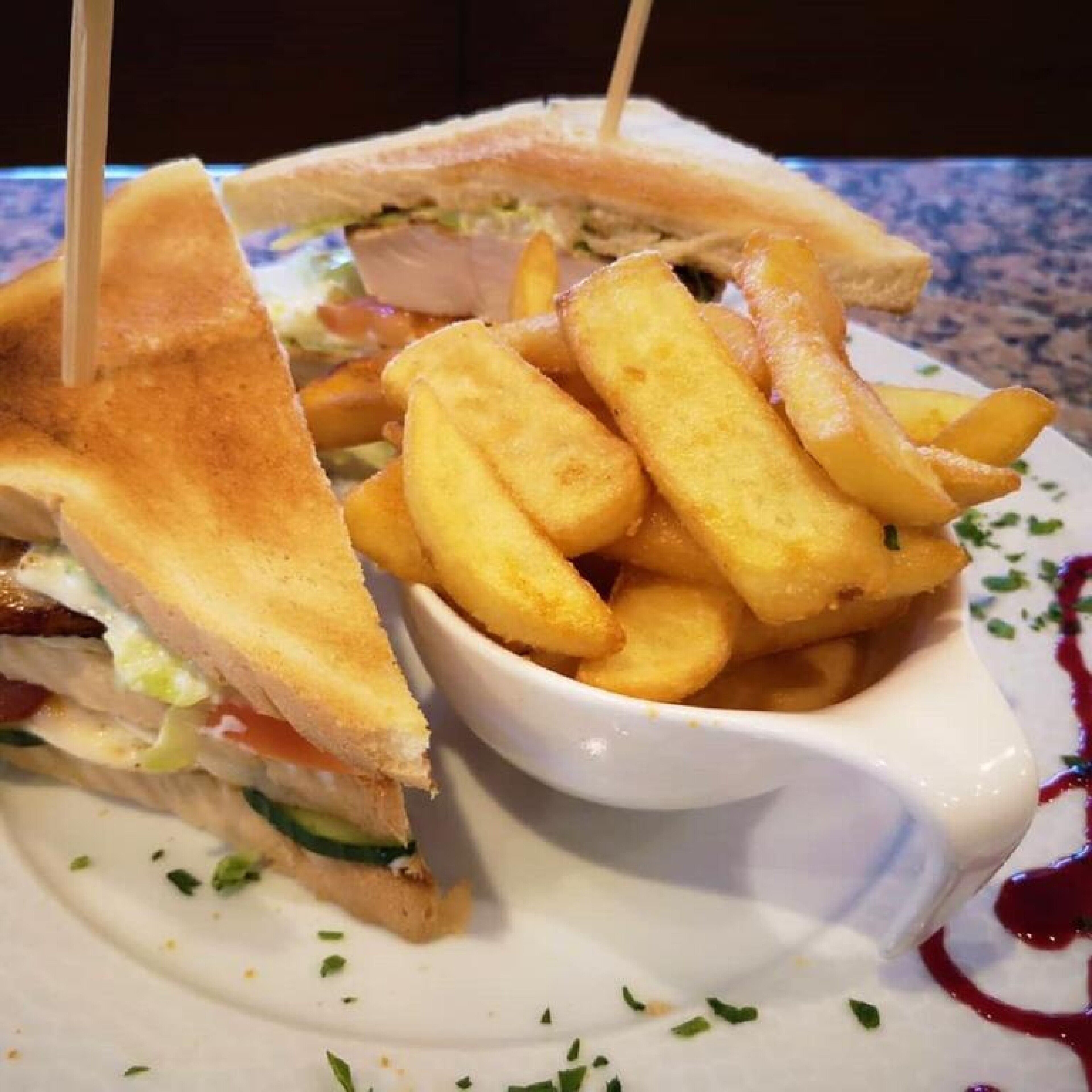 A sandwich with french fries on a plate.