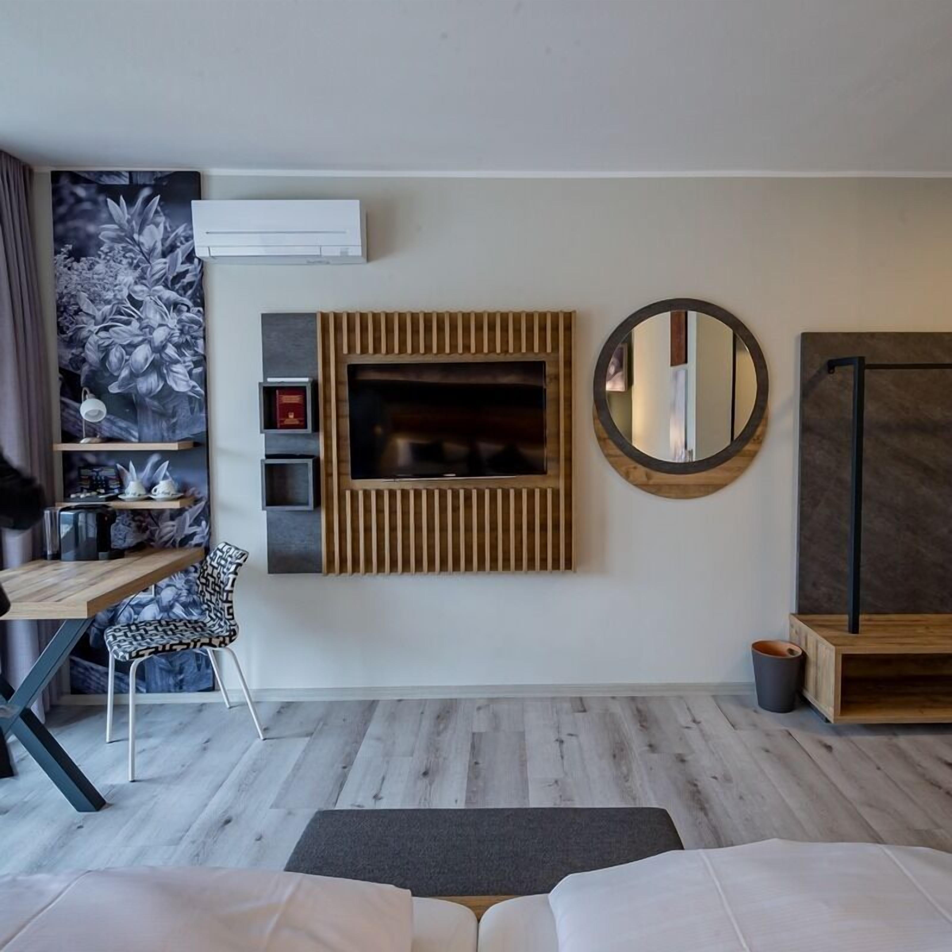 Un salon moderne avec une cheminée, un miroir rond et une table basse.
