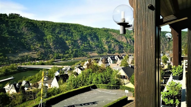 A view of a residential area with houses, a river, and a bridge in the background. - Hotel Hegenbarth's (Cochem)