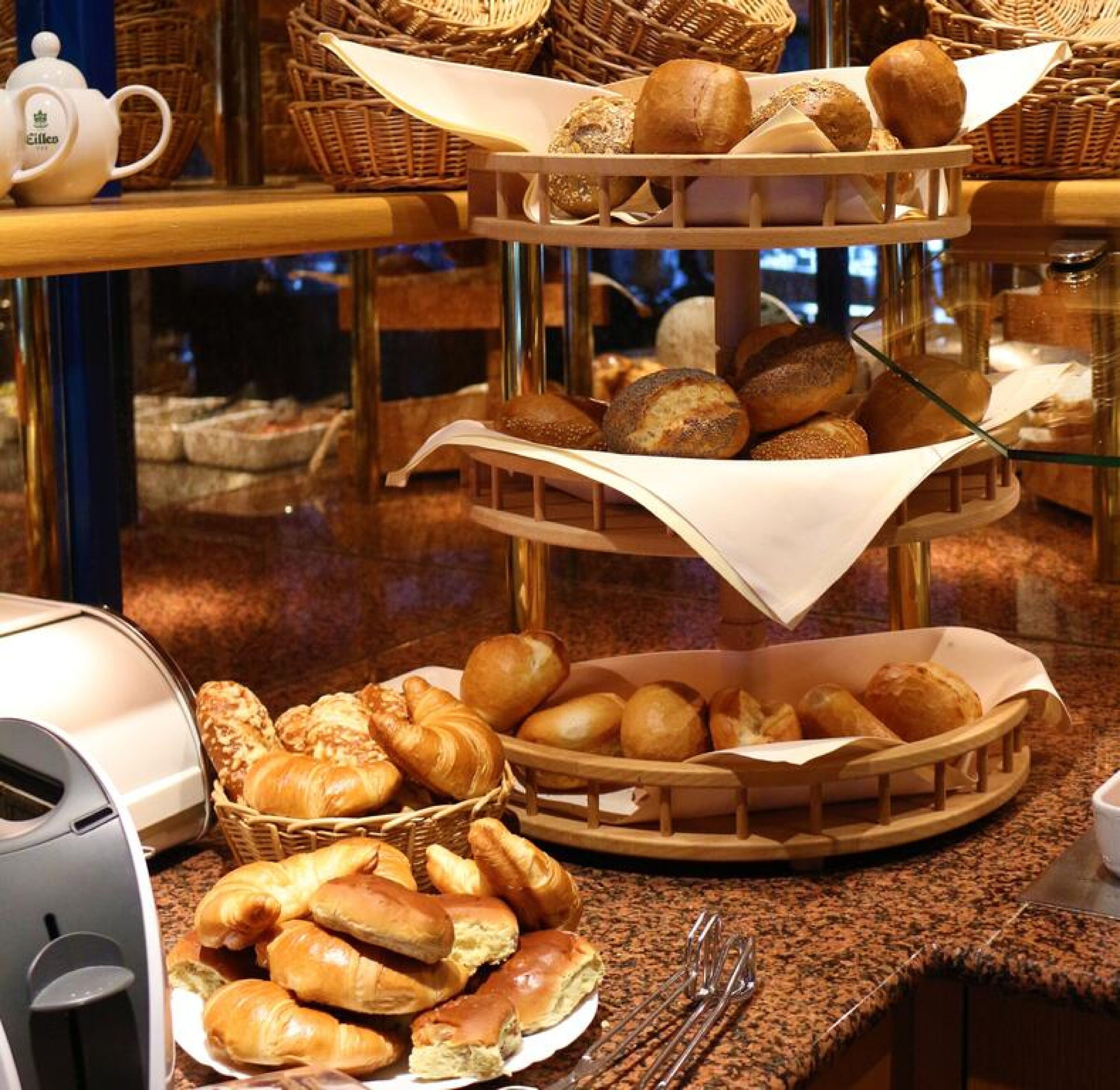 Ein Buffet mit verschiedenen Brotsorten und Gebäcken, präsentiert auf gestapelten Etageren.