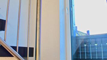 A staircase with metal railings and a window leading to an outdoor area.