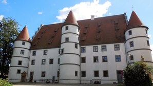Um edifício grande e histórico com várias torres e um pátio central.