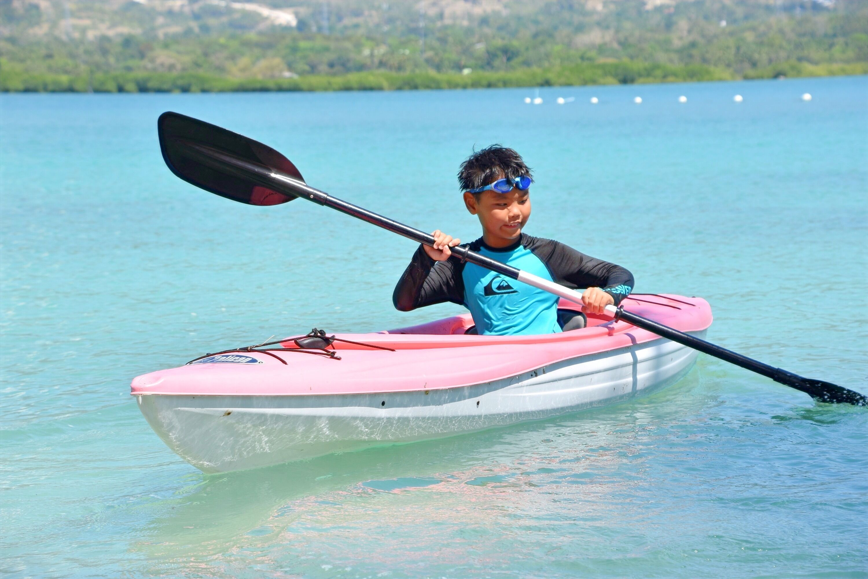 A person in a kayak on a calm body of water.