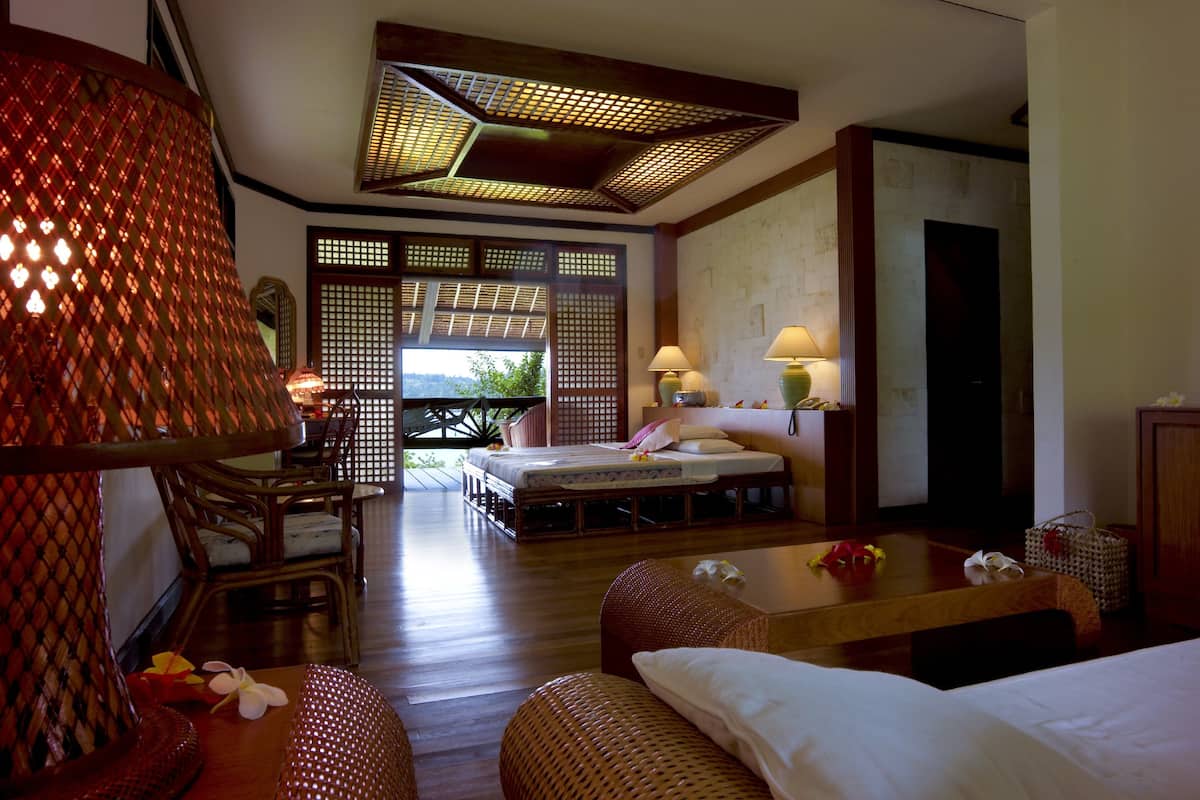 Ein traditioneller japanischer Raum mit Tatami-Böden, einem niedrigen Holzbett und einer Schiebetür, die zu einem Balkon führt.
