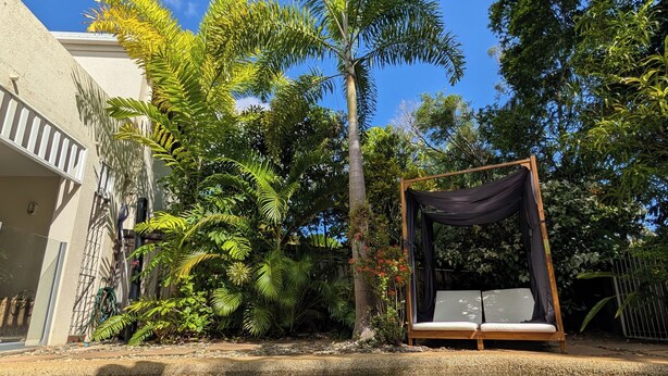 A clear swimming pool with a wooden deck and a lounge chair. - The Villas Palm Cove (Palm Cove)