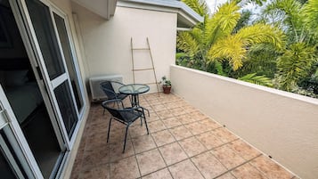Enjoy a tranquil retreat with a balcony featuring a table, chairs, and lush greenery.