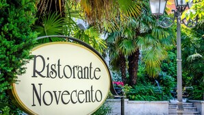Señalización para el restaurante Ristorante Novecento en un exuberante jardín.
