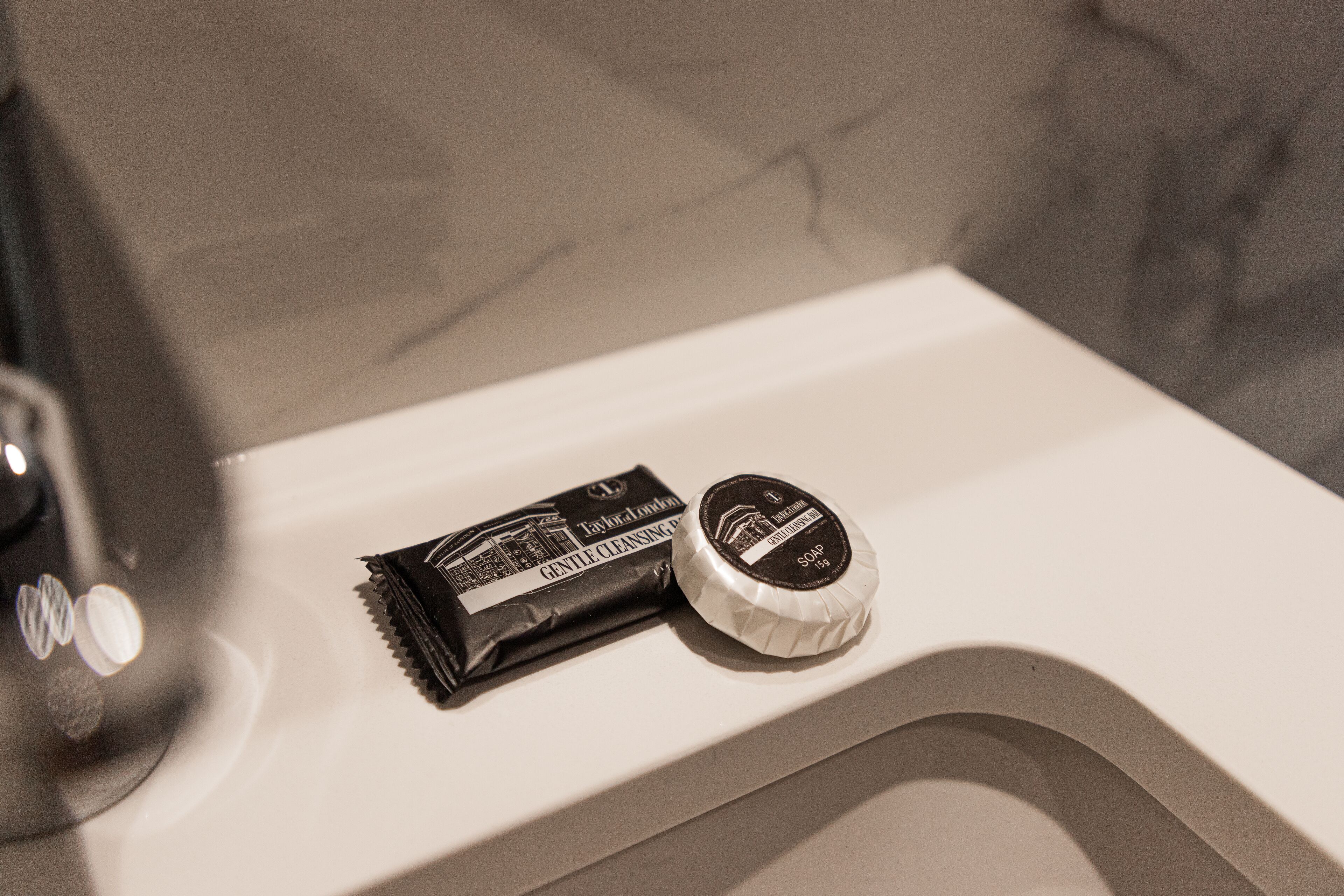 Un lavabo de salle de bain avec un savon en barre et un flacon de savon liquide.