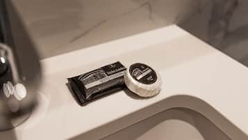 Un lavabo de salle de bain avec un savon en barre et un flacon de savon liquide.