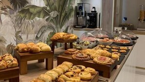 Een buffet met diverse gebakjes en een koffiehoek.