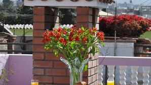 A table with breakfast items, a vase with flowers, and a mountain view in the background. - Casa Arequipa (Arequipa)