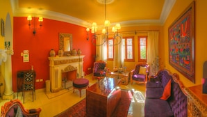 A brightly colored living room with a fireplace, a chandelier, and a large painting. - Casa Arequipa (Arequipa)