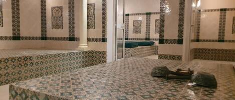 A bathroom with patterned tiles, a sink, and a toilet.