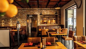 A restaurant with brick walls, leather booths, and wooden tables. - Hotel Ochsen (Bad Saulgau)