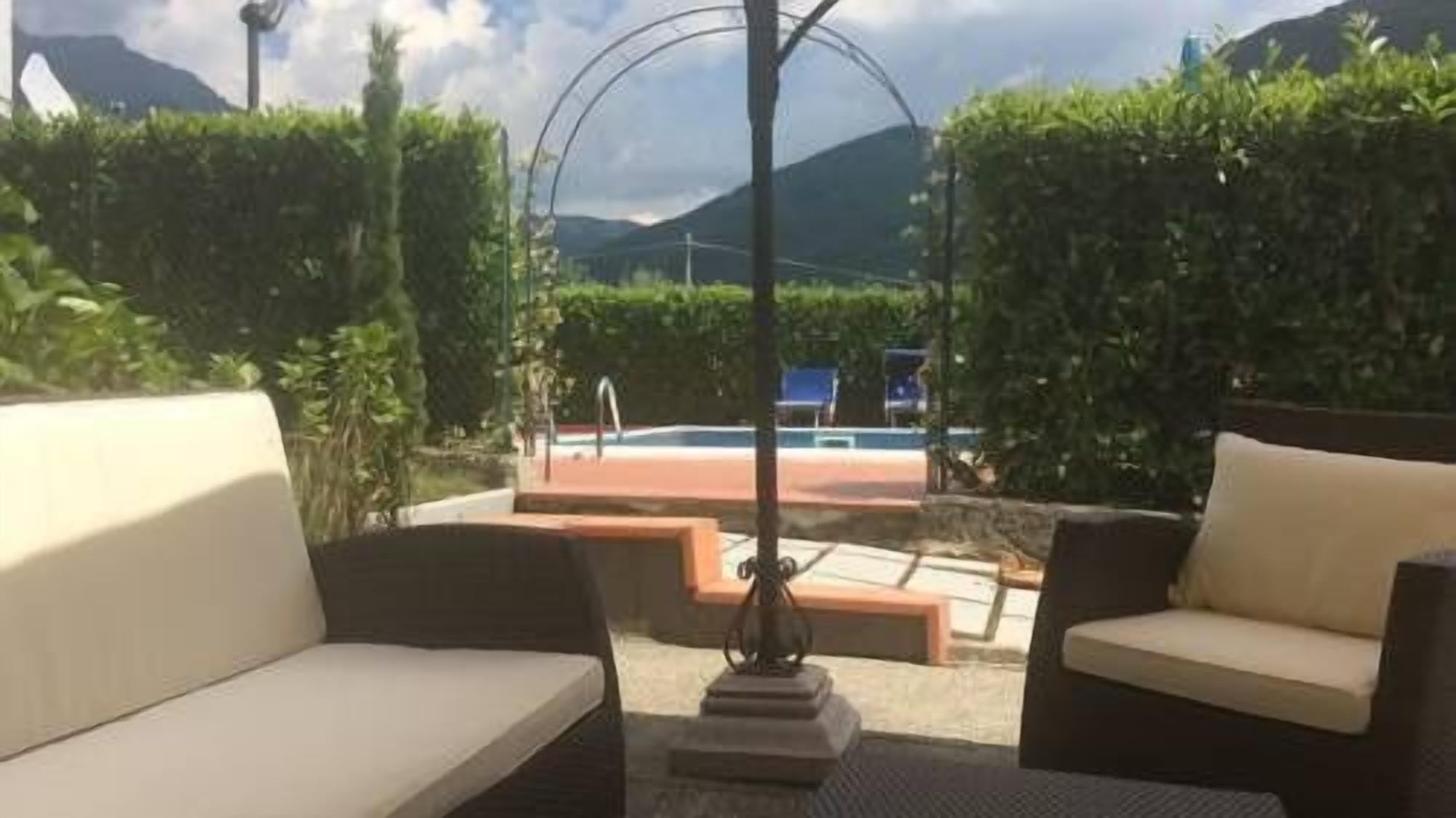 Ein Außenbereich mit Sitzgelegenheiten, zwei Sofas, einem Pool und Blick auf Berge.