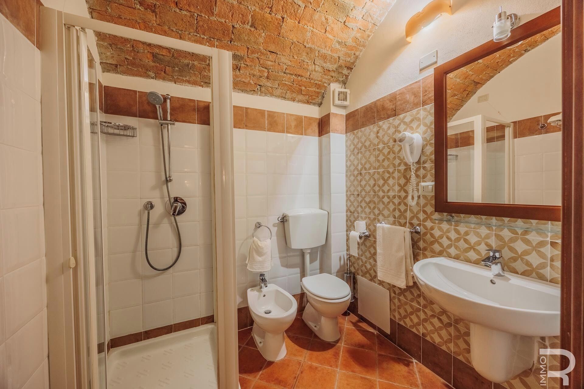 Un baño con ducha, inodoro, bidé y lavamanos.