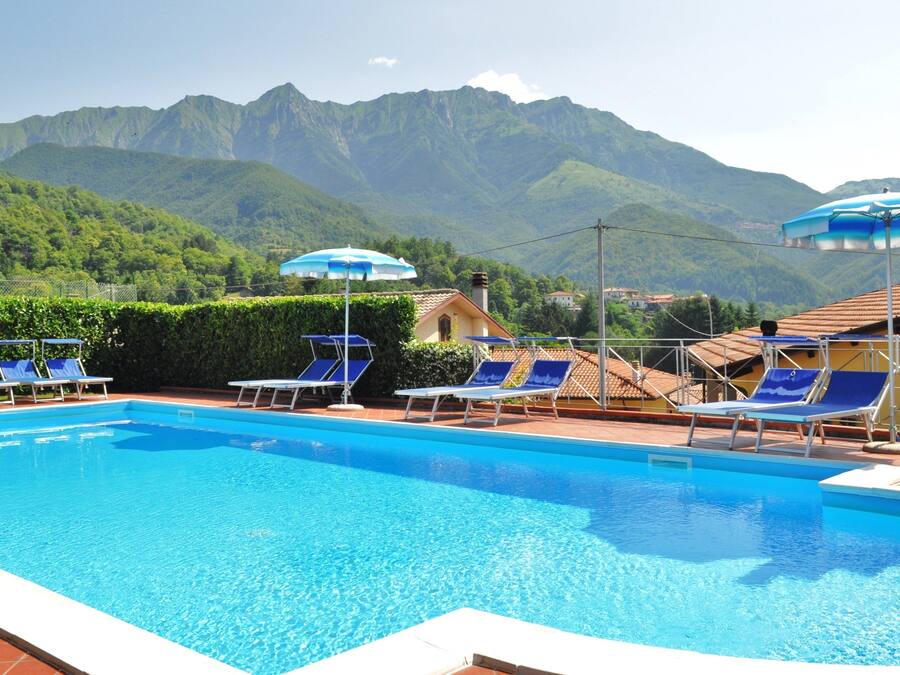 Een buitenzwembad en ligstoelen