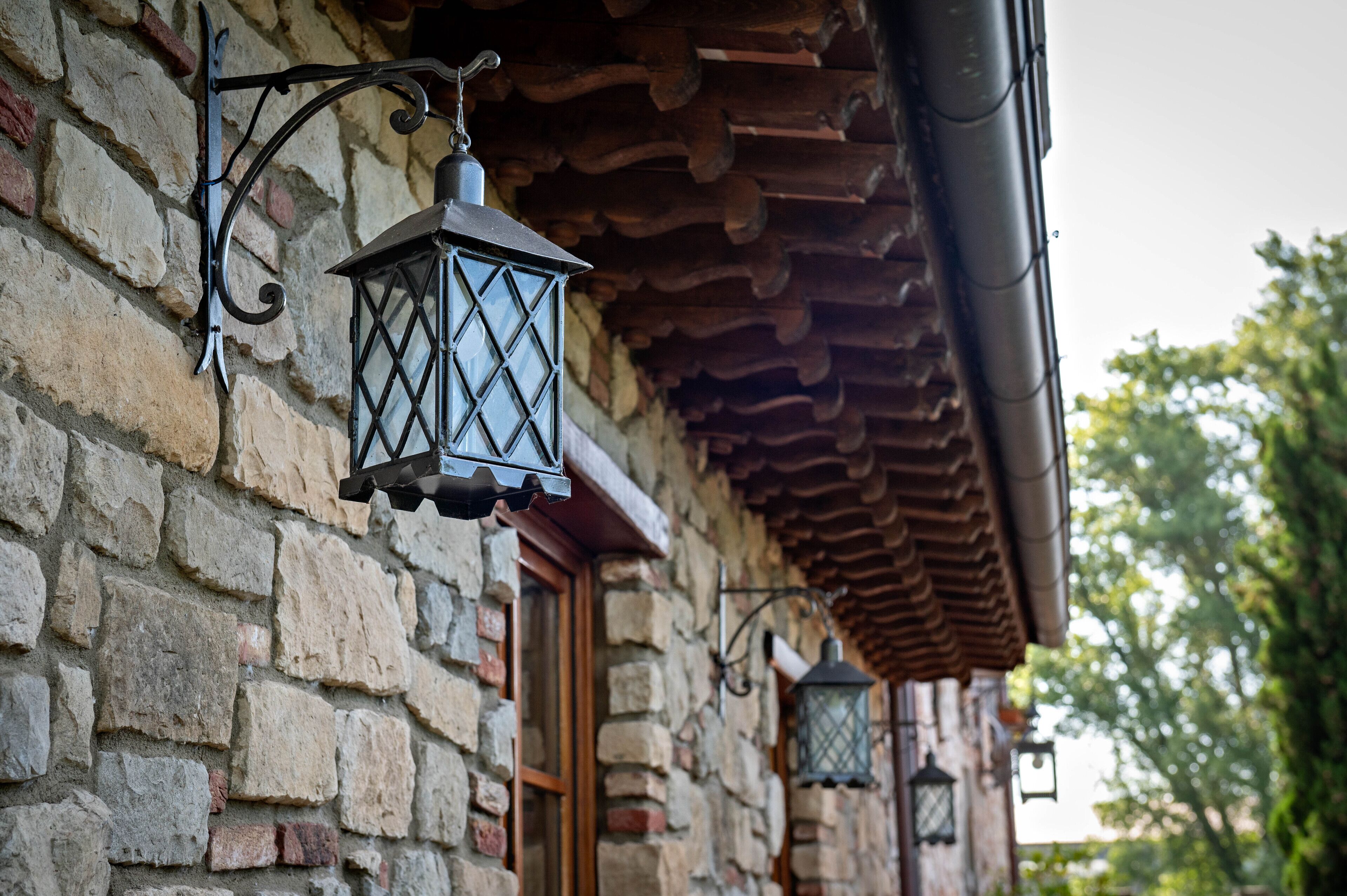Un edificio de piedra con una puerta de madera y un farol colgando de la pared.