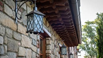 A stone building with a wooden door and a lantern hanging from the wall.