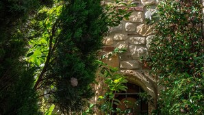 A stone building with a window and a small archway. - Villa Corte Degli Dei (Lucca)