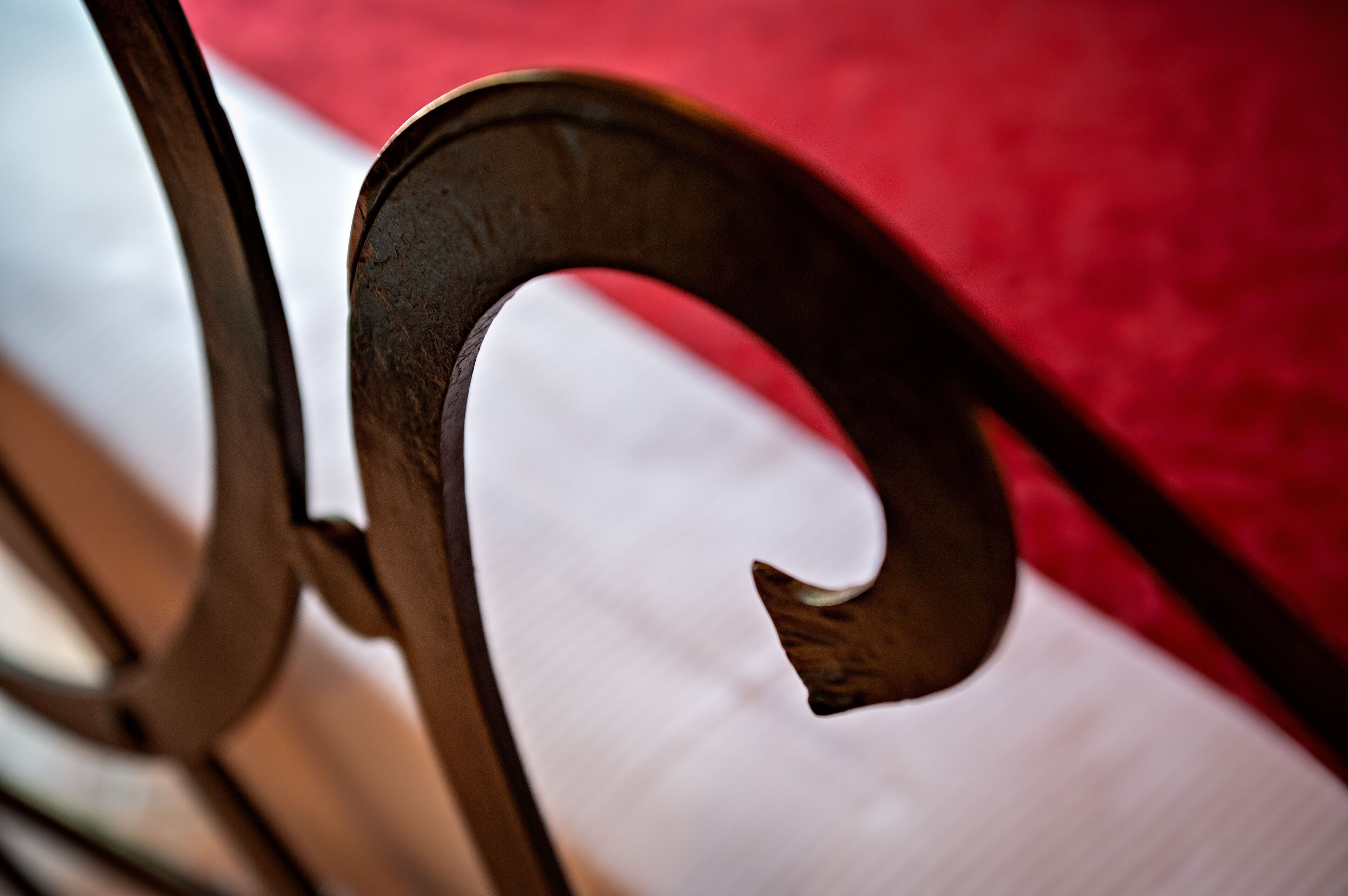 A close-up of a metal chair with a curved backrest.